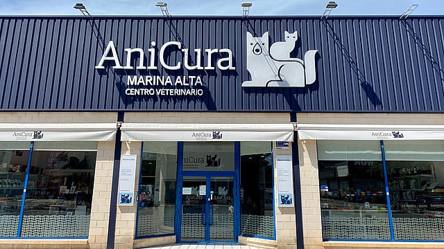 Una fachada de tienda con un letrero en el costado.
