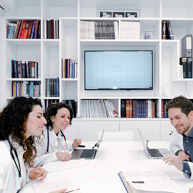Un grupo de personas con batas de laboratorio sentadas en una mesa.