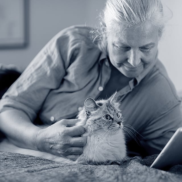 Una persona acostada en una cama con un gato.
