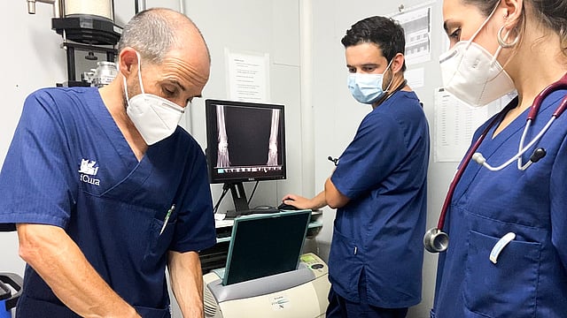 Un grupo de personas con uniformes médicos y mascarillas.