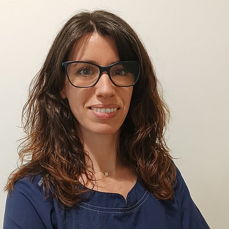 Una persona con gafas y sonriendo.