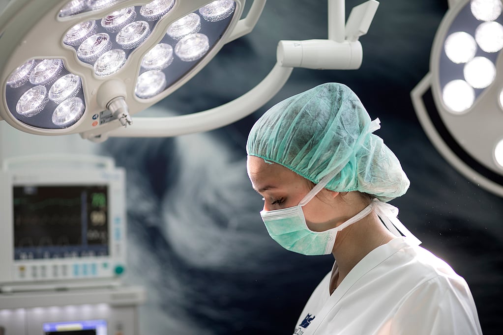 A person in a surgical mask and cap.