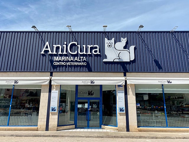 Una fachada de tienda con un letrero en el costado.